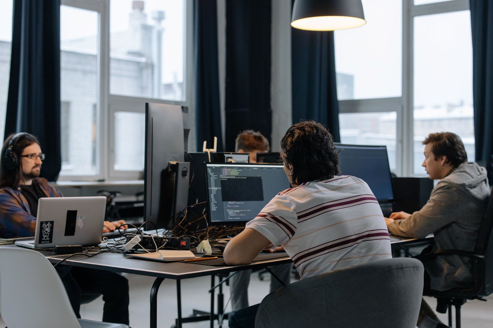 Developers collaborating at their workstations in a modern technology startup office