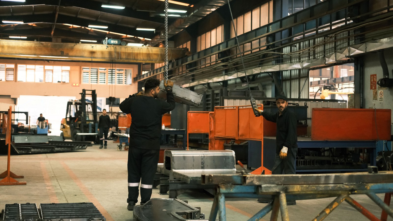 Industrial workers operating machinery on a manufacturing facility floor, representing the mid-market manufacturer case study